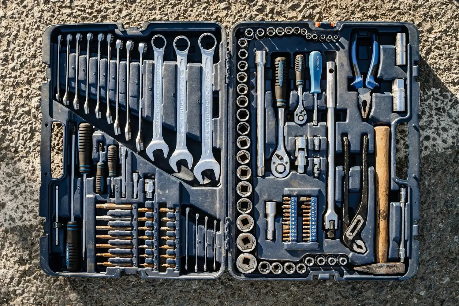 An open toolbox on a cement ground.