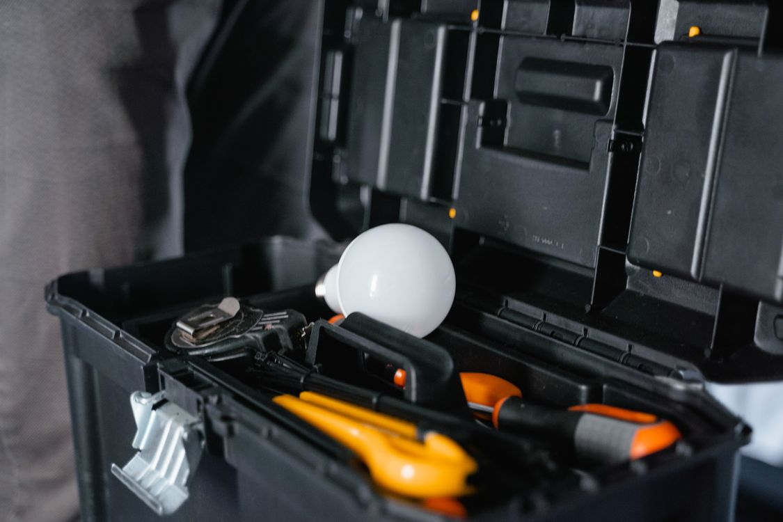 open toolbox displaying orange tools and a stray lightbulb.